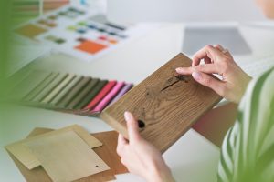 Interior designer at work, holding wood sample in hands