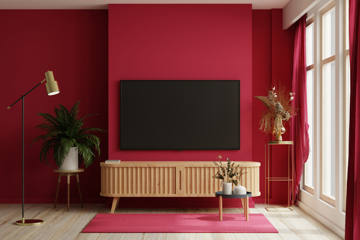 TV on the cabinet in modern living room on white viva magenta wall background.
